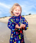 Beach swim parka worn by toddler on the beach. Swim parka is water resistant and keeps children warm after swimming. 