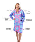 Adult wearing mermaid print swim parka. pIcture displays key features of the schmik schmik swim parkas such as, fitted hood, detachable sleeves, adjustable velcro sleeves, towel lining, extra long length, showerproof outer. 