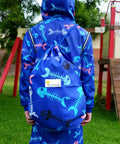Child wearing matching blue fihbone print swim parka and blue fishbone print swim bag. 