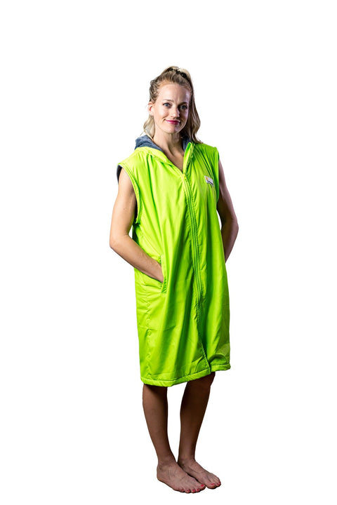 Lady is wearing a fluro green schmik swim parka and has her hand in the pockets. Fluro green swim parka come in adults and kids sizes and has a showerproof outer.