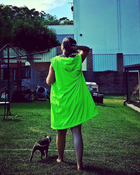 Fluro green swim parka worn by lady. Swim parka has its harms unzipped. 